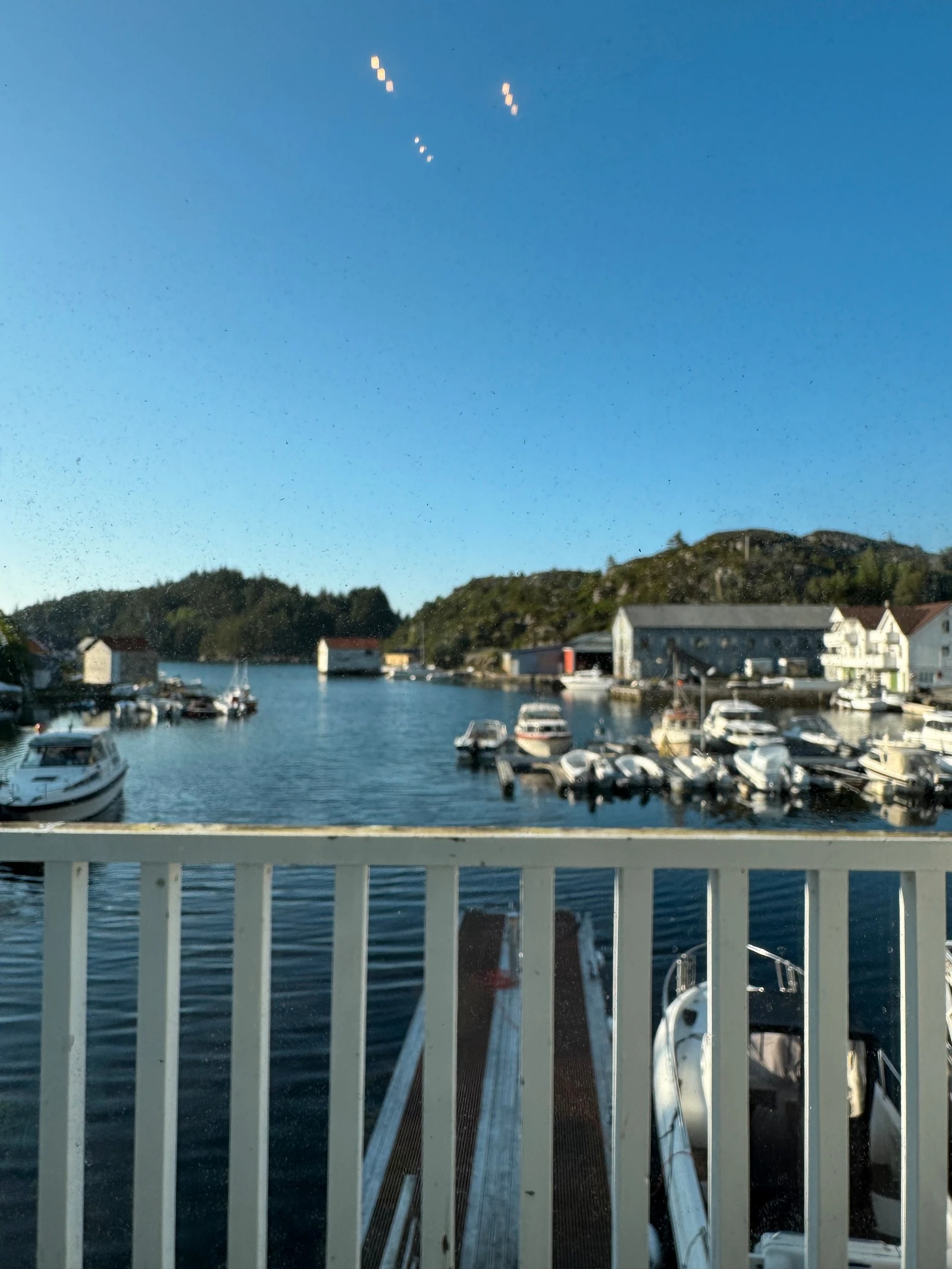 Utsikt fra balkong mot båthavn
